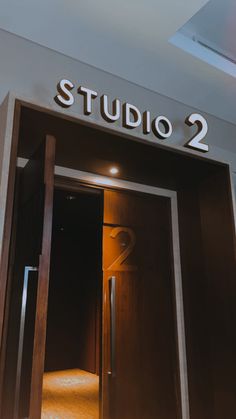 an open door with the number 2 on it in front of a sign that reads studio 2