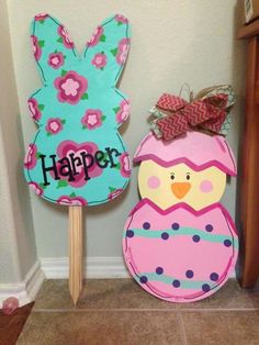 two wooden signs with flowers on them and an owl standing next to one that says happy