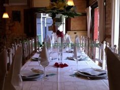 the table is set with white linens and place settings