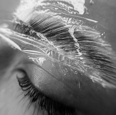 a woman's eye with long eyelashes and clear plastic covering the top part of her lashes