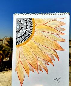 a drawing of a sunflower on a white sheet with blue sky in the background