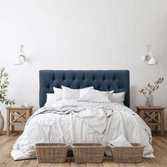 a bed with white linens and two wicker baskets on the headboard next to it