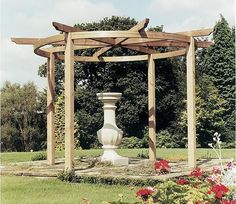 a garden with flowers and a stone statue in the middle