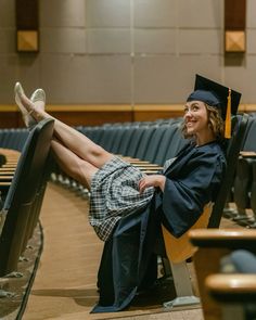 a woman in graduation cap and gown sitting on a bench with her legs crossed out