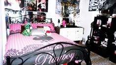 a bedroom decorated in black and pink with pictures on the wall