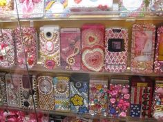 there are many cell phones on display in the store case, all decorated with different designs and colors