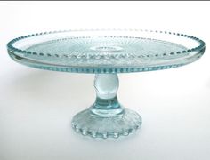 a glass cake plate sitting on top of a table