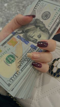 a woman's hand holding money in her purse