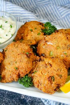 some fried food on a white plate with lemon wedges and sour kraut