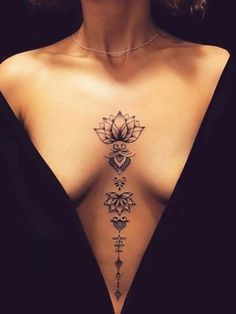 a woman's back with a tattoo design on her left shoulder and the top part of her chest