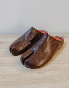 Beautiful handmade leather Japanese Tabi mules  with split toe design,completely hand stitched from top to bottom. The boots are made with soft supple leather and are very comfortable and will mold to your foot with time. Pre order: Please note these mules are made upon order and will take 4-6 weeks to complete and ship. Handmade with top quality materials and stacked leather soles. The shoes will have minor imperfections do to handmade handling and painting. Sizes: 7-11 or 37-41 Please contact Leather Closed Toe Slippers For Fall, Leather Mules With Plain Toe And Stitched Sole, Leather Mules With Stitched Plain Toe, Leather Mules With Stitched Sole And Plain Toe, Fall Slip-on Mules With Leather Lining, Fall Leather Lining Slip-on Mules, Leather Slippers With Rubber Sole For Fall, Leather Slip-on Mules With Single Toe Strap, Fall Leather Slippers With Rubber Sole