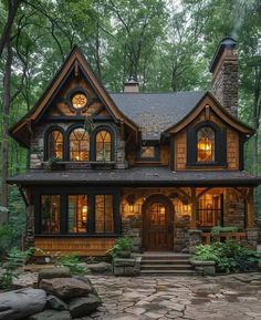 a house that is in the woods with lots of windows and stone steps leading up to it