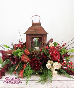 a lantern is surrounded by flowers and greenery