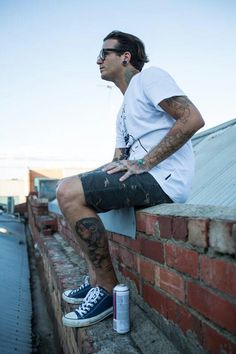 a man sitting on top of a brick wall