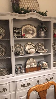 a china cabinet with plates and silverware on it