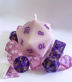 a purple and white dice with numbers on it sitting next to some other dices