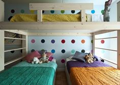 there are two beds in the room with polka dots on the wall and one has a stuffed animal