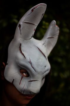 a person wearing a white bunny mask with red streaks on their face