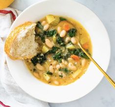 a white bowl filled with soup next to a piece of bread