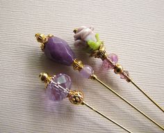 three pins with beads and flowers on them