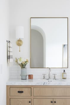 a bathroom vanity with two sinks and a large mirror on the wall above it,