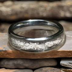 a close up of a wedding ring on some rocks