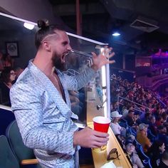 a man drinking from a red cup in front of an audience