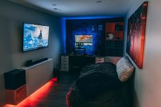 a bedroom with two televisions on the wall and a bed in front of it