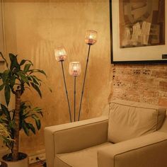 a living room filled with furniture and a potted plant next to a painting on the wall