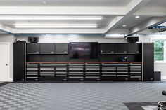 an empty garage with black cabinets and tools