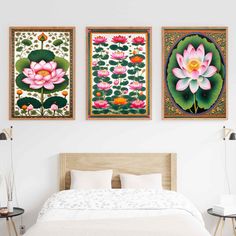 three paintings hang on the wall above a bed