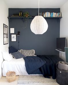 a bedroom with a bed, bookshelf and rugs on the floor in front of it