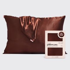 the pillow case is brown and has a satin cover on it, along with an envelope