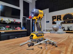 a cordless drill and screwdriver sitting on top of a wooden table in a garage