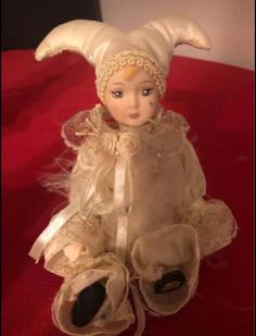 an old doll is sitting on a red surface