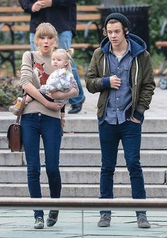 the young couple are walking down the steps with their baby in his arms and one is holding