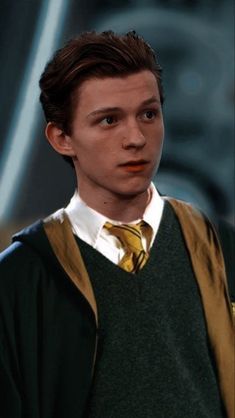 a young man wearing a green sweater and yellow tie