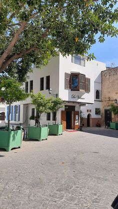 a white building with green planters in front of it