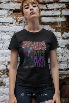 a woman standing in front of a brick wall wearing a t - shirt that says zombies were people too