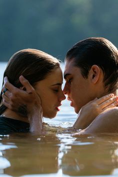 two people in the water kissing each other