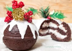 there is a chocolate cake with white frosting and holly decorations on top, next to a roll