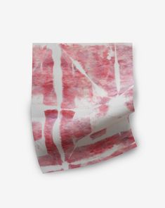 a red and white tie dyed scarf on top of a white surface with lines drawn across it