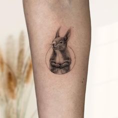 a small rabbit tattoo on the right inner forearm and leg, with a circle around it