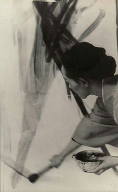 an old black and white photo of a woman painting