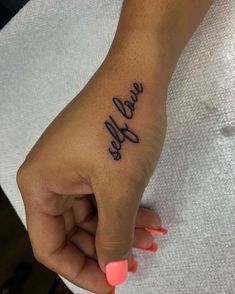 a woman's hand with a small tattoo on it that says, selfie