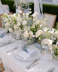 the table is set with white and blue flowers