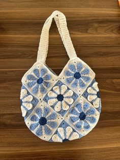 a crocheted bag sitting on top of a wooden table