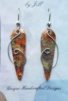 a pair of earrings made from copper and silver