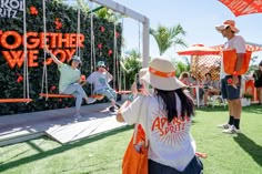 people taking pictures at an orange and white event