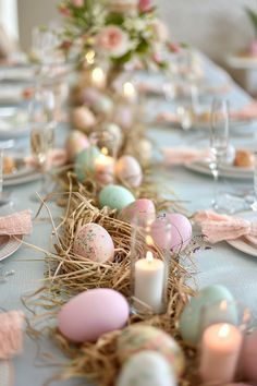 an easter table setting with candles and decorated eggs